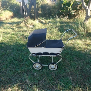 Kleine en oude speelgoedkinderwagen voor kinderen Body van hout geschilderd in wit en blauw en staal