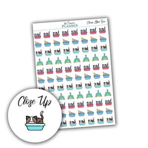 May include: A sheet of stickers featuring a cat in a litter tray, a scoop, and a litter tray with litter. The stickers are in various colours, including blue, green, pink, and yellow. The text "Clean Litter Box" is at the top of the sheet. The text "the Prairie PLANNER" is in the top left corner of the sheet.