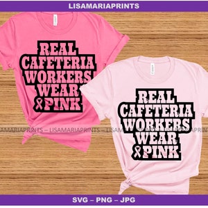 May include: Two pink t-shirts with the text "Real Cafeteria Workers Wear Pink" and a pink ribbon graphic. The text is in black bold letters.