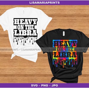 May include: Two t-shirts with the text "Heavy on the Libra" in black lettering. The first t-shirt is white with black dripping paint. The second t-shirt is black with a rainbow tie-dye design and black dripping paint.
