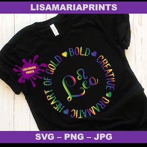 May include: A black t-shirt with a rainbow circle design that says "Heart of Gold", "Bold", "Creative", and "Dramatic" around the word "Lea".