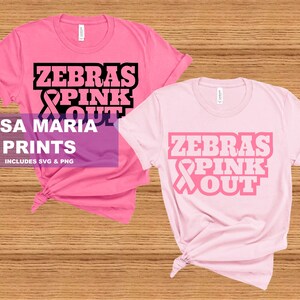 May include: Two pink t-shirts with the text "Zebras Pink Out" and a pink ribbon graphic. The text is in black and the ribbon is in pink.