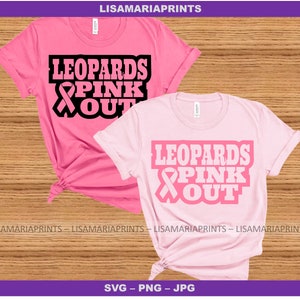 Puede incluir: Dos camisetas rosas con el texto "Leopards Pink Out" y un gráfico de cinta rosa. El texto está en negro y la cinta es rosa.