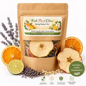 Könnte beinhalten: Ein Kraftpapierbeutel mit Sichtfenster, gefüllt mit getrockneten Früchten und Pflanzen. Auf dem Etikett steht "Fresh Floral Citrus Spring Simmer Pot". Um den Beutel herum sind Orangen, Limetten und Lavendelzweige angeordnet. Ein grüner Kreis zeigt "Natural Home Fragrance".