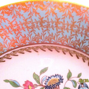 May include: A vintage porcelain bowl with a blue and gold floral design. The bowl has a scalloped edge and a delicate floral pattern.