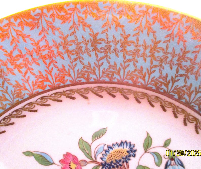 May include: A vintage porcelain bowl with a blue and gold floral design. The bowl has a scalloped edge and a delicate floral pattern.