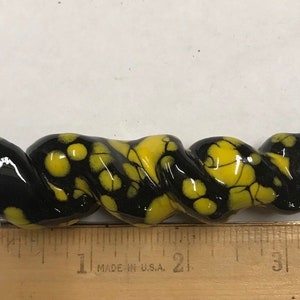 以下が含まれることがあります： 黒と黄色の斑点模様のセラミックの渦巻き。渦巻きは約5センチメートルです。