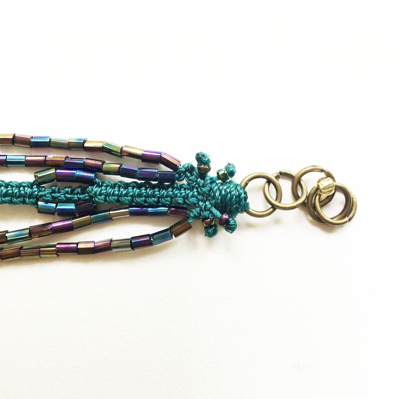 Macrame bracelet with brass cat charm and glass rainbow tube and seed beads and square light pink glass beads
