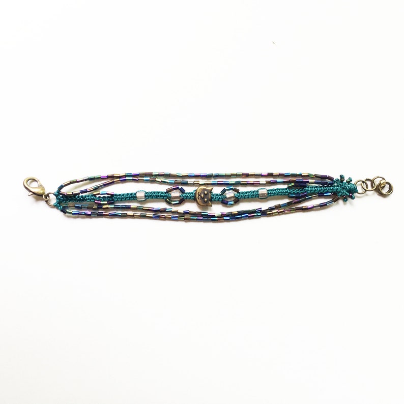 Macrame bracelet with brass cat charm and glass rainbow tube and seed beads and square light pink glass beads