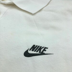 Pu&ograve; includere: Polo bianco con logo Nike nero sul petto.