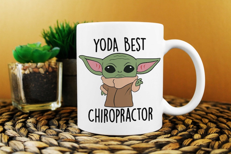 May include: White ceramic mug with a green cartoon character with large ears and the text "YODA BEST CHIROPRACTOR" printed on it.
