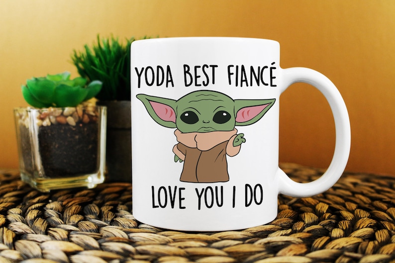 Puede incluir: Taza de cer&aacute;mica blanca con un personaje de dibujos animados verde y el texto "YODA BEST FIANC&Eacute; LOVE YOU I DO"