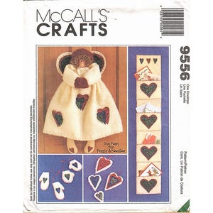 May include: A McCall's Crafts sewing pattern envelope. The pattern features an angel-shaped wall hanging with heart-shaped accents, a pocket organizer, and heart-shaped ornaments. The text "Sue Penn for Penn's & Needles" is visible.
