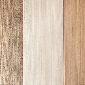 May include: Three wood panels with different grain patterns. The panel on the left is a dark brown wood with a fine grain. The middle panel is a light brown wood with a straight grain. The panel on the right is a medium brown wood with a straight grain.