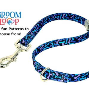 May include: A blue and purple dog lead with a bone pattern. The lead has a silver clip and a silver ring.