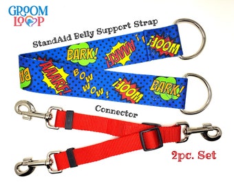 May include: A blue and red dog belly support strap with a comic book print and two silver D-rings. The strap is labeled "StandAid Belly Support Strap" and features the text "Bark!" and "Woof!" in a comic book style. The strap is connected to a red connector with two silver clips. The text "2pc. Set" is visible in the lower right corner of the image.