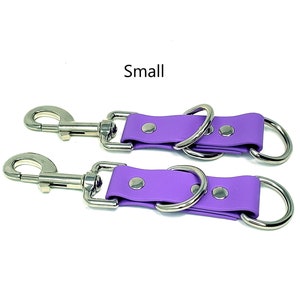 May include: Two purple leather straps with silver metal rings and clips. The straps are labeled "Small".