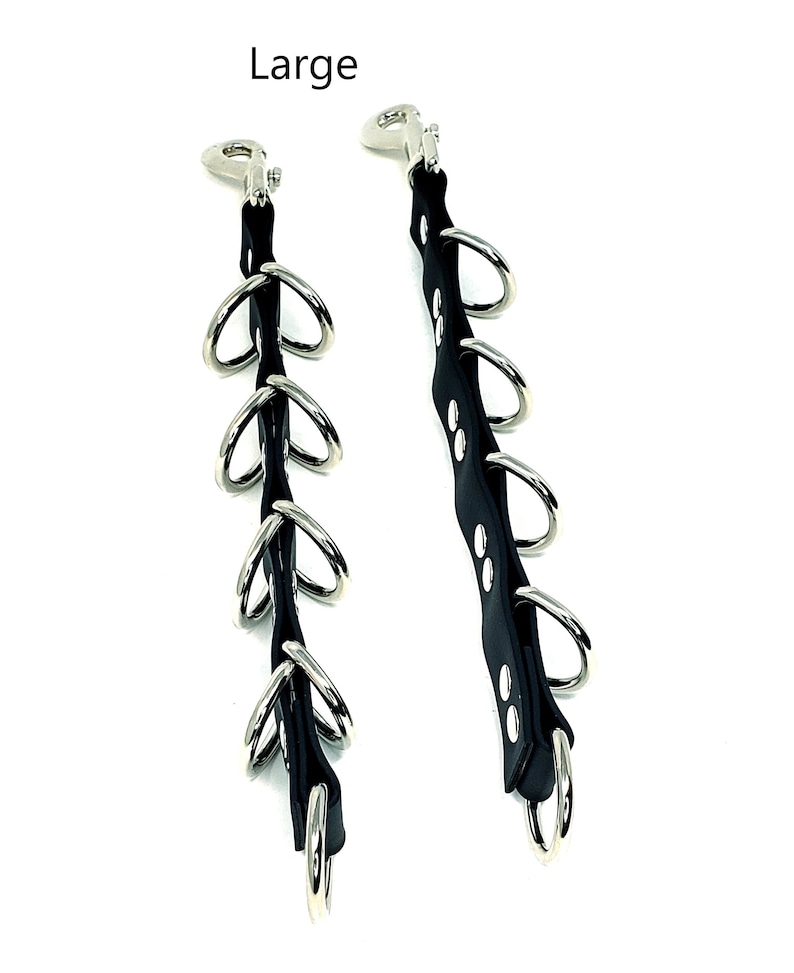 May include: Two black leather straps with silver metal rings and clips. The straps are about 12 inches long and have five rings each. The rings are about 1 inch in diameter. The straps are labeled "Large".