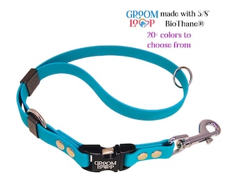 May include: A turquoise blue dog collar with a black buckle and silver hardware. The collar is made with 5/8" BioThane and has the text "Groom Loop" on the buckle. The collar is shown on a white background. 20+ colors to choose from.