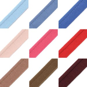 May include: Nine samples of different colored ribbon with a single stitch down the center. The colors are light blue, blue, pink, red, beige, brown, and burgundy.