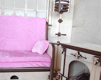 May include: A pink sofa with two pillows and a wooden drawer underneath. A wooden fireplace with a decorative mantel and a log holder is on the right side of the image.
