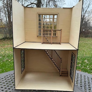 Könnte beinhalten: Ein Holzpuppenhaus mit zwei Etagen, einer Treppe und einem Fenster. Das Puppenhaus ist aus unbehandeltem Holz und hat ein schlichtes Design.