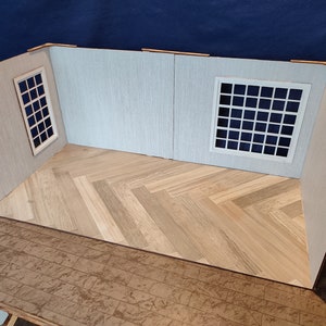 May include: A model room with white walls and a wood floor. The room has two windows with white frames.