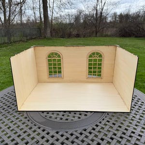 Può includere: Una stanza di casa delle bambole in legno con due finestre ad arco. La stanza è incompleta e pronta per essere decorata.