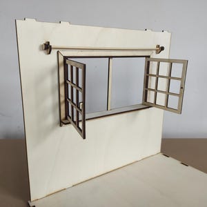 May include: A wooden model of a window with a white frame and a brown paneled window. The window is open and the panes are visible. The window is mounted on a white wooden wall.
