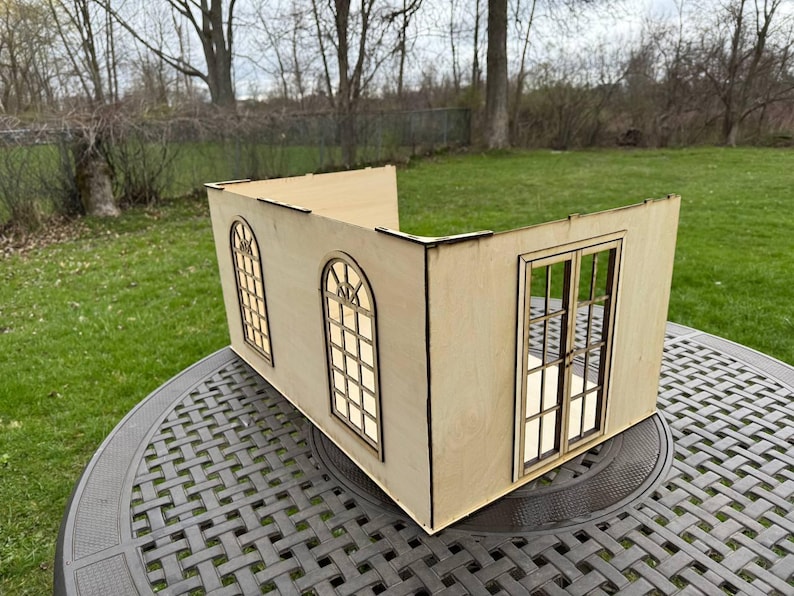 Puede incluir: Un modelo de casa de madera con dos ventanas y una puerta doble. El modelo est&aacute; hecho de madera clara y tiene un acabado natural.
