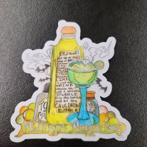 Puede incluir: Una pegatina con una ilustración dibujada a mano de un cóctel margarita con una rodaja de lima verde. El texto de la pegatina dice "EYE of Newt AND THE of FRU WOOL of BAT DOG ADDUSTRY FUCK AND STING Barbados LIME is just the THING CRAGGED SALT LIKE A SAILOR'S STUBBLE Flip the switch and let the CAULDRON BUBBLE Midnight Mangaritas".