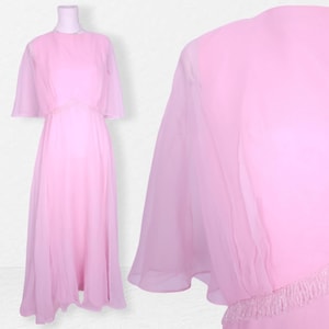 May include: A long, flowing pink chiffon dress with a round neckline and short, bell sleeves. The dress has a beaded waistband and a flowing skirt.