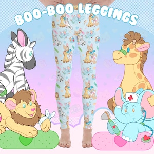 Könnte beinhalten: Eine blaue Leggings mit einem Muster aus Comic-Tieren, die Verbände tragen. Zu den Tieren gehören ein Zebra, eine Giraffe, ein Löwe und ein Elefant. Die Leggings hat den Text "BOO-BOO LEGGINGS" aufgedruckt.