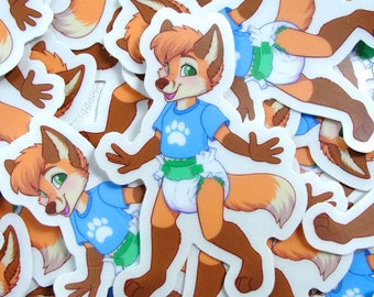 May include: A collection of die-cut stickers featuring an anthropomorphic orange fox character with brown fur accents, green eyes, and a light brown tuft of hair. The fox wears a blue t-shirt with a white paw print and a white diaper with green tabs.