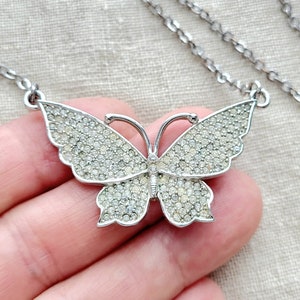 Vintage silvertone clear pave rhinestone butterfly pendant necklace. 17&quot; stones have color variation due to age.