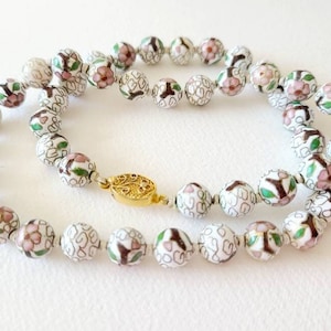Vintage cherry blossom floral cloisonne bead necklace, hand knotted, pink flower, white background, gold tone clasp.