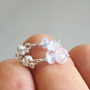 May include: Silver earrings with clear quartz stones. The earrings are made with wire and have a simple design.