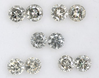 May include: Eight round, clear, faceted, gray diamonds. The diamonds are arranged in three rows of two diamonds each.