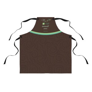 May include: Brown kitchen apron with a swirl pattern and a green and white stripe across the top. The text "My cup runneth over. Psalm 23:5" is printed on the apron.