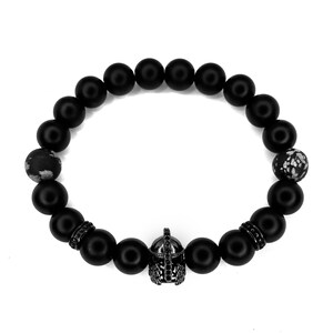 May include: Black beaded bracelet with a black metal gladiator helmet charm. The beads are matte black and have a slightly textured surface.