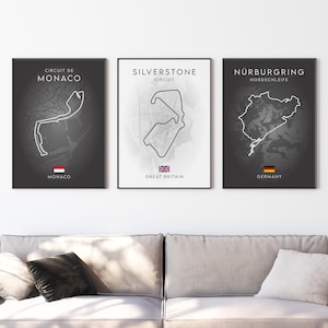 May include: Three black and white prints of famous race tracks. The prints are titled "Circuit de Monaco", "Silverstone Circuit", and "Nürburgring Nordschleife". Each print features a map of the track and the country's flag.