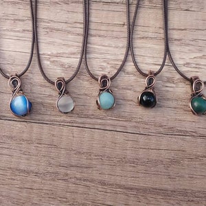 May include: Eight necklaces with copper wire wrapped around different colored stones. The stones are a mix of blue, white, green, black, and brown.