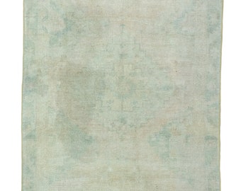 May include: A light green vintage rug with a faded pattern. The rug has a subtle distressed look and a soft, worn texture.
