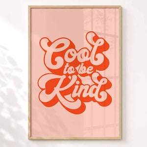 K&ouml;nnte beinhalten: Ein gerahmter Wandkunstdruck mit dem Text Cool to be Kind in einer fetten, stilisierten orangefarbenen Schrift mit einem zartrosa Schlagschatten. Der Schriftzug ist auf einem hellrosa Hintergrund zentriert und von einem hellen Holzrahmen umgeben.