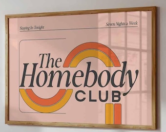 May include: A framed wall art print with a light pink background featuring the text The Homebody CLUB in dark gray, accented by orange and yellow semi-circular arches. The top corners display the text Staying In Tonight and Seven Nights a Week.