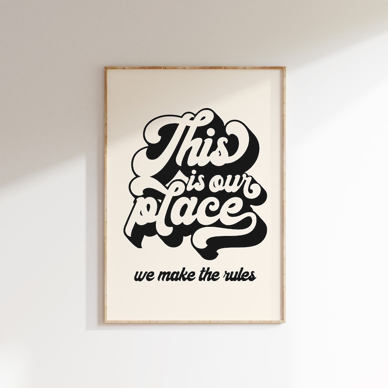 May include: Black and white typography print with the text "This is our place we make the rules" on a cream background.