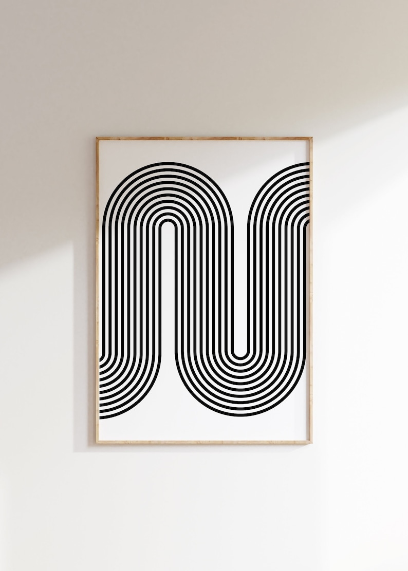 Puede incluir: Impresi&oacute;n de arte abstracto en blanco y negro con un dise&ntilde;o geom&eacute;trico de l&iacute;neas curvas que forman un patr&oacute;n de onda. La impresi&oacute;n est&aacute; enmarcada en un marco de madera claro.