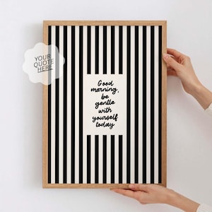 Op de afbeelding: Een ingelijste print met een zwart-wit gestreepte achtergrond. De print bevat de tekst "Good morning, be gentle with yourself today" in zwart schrift. Een wolkvormig element leest "YOUR QUOTE HERE". De lijst is gemaakt van lichtgekleurd hout.