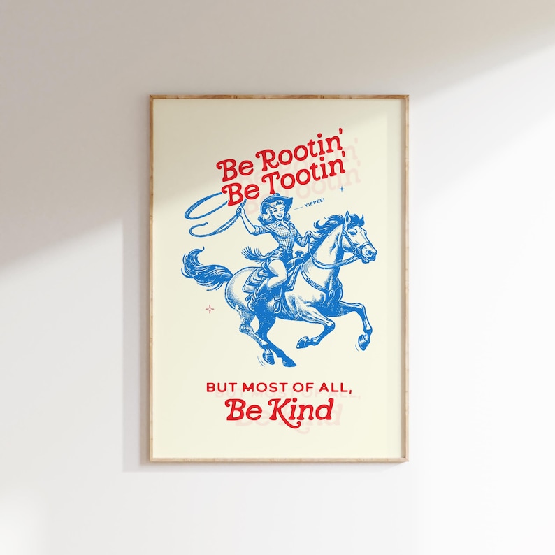 Pu&ograve; includere: Un poster in stile vintage con un'illustrazione blu di una donna a cavallo. Il testo sul poster recita "Be Rootin' Be Tootin' But Most of All, Be Kind".