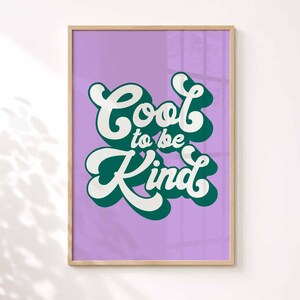 Puede incluir: Una l&aacute;mina enmarcada con fondo morado claro y el texto Cool to be Kind escrito en una fuente retro blanca y negrita. Las letras tienen una sombra paralela de color verde oscuro, creando un efecto de capas dentro de un marco de madera clara.